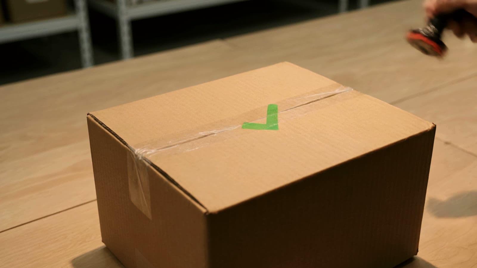Geprüft-Stempel mit grünem Haken auf einem Karton